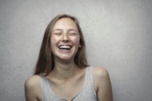 Photo by Andrea Piacquadio: https://www.pexels.com/photo/woman-in-gray-tank-top-laughing-3812740/ Happy teenage girl smiling with braces.