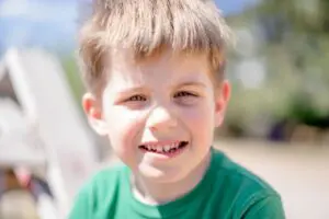 Photo by Atlantic Ambience: https://www.pexels.com/photo/boy-in-green-crew-neck-shirt-smiling-12969391/ boy smiling with baby teeth 