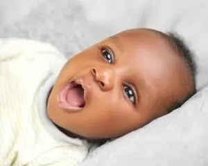 Image URL: Photo by Ayobami Adepoju: https://www.pexels.com/photo/baby-with-mouth-open-17471734/ Alt Text: A smiling infant post frenectomy in Mansfield TX