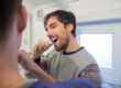 https://www.pexels.com/photo/man-in-gray-long-sleeve-shirt-brushing-teeth-6670234/ Adult male with short brown hair brushing his teeth