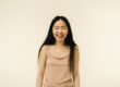 https://www.pexels.com/photo/an-asian-woman-laughing-in-front-of-camera-9774566/ Young woman with long black hair smiling with braces